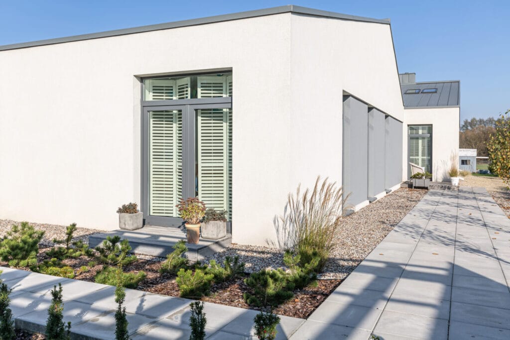 back view of modern suburban house with trendy backyard with concrete path