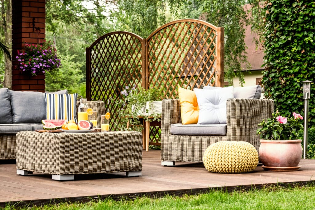 grapefruit and orange juice on the table on wooden terrace with yellow pouf next to armchair